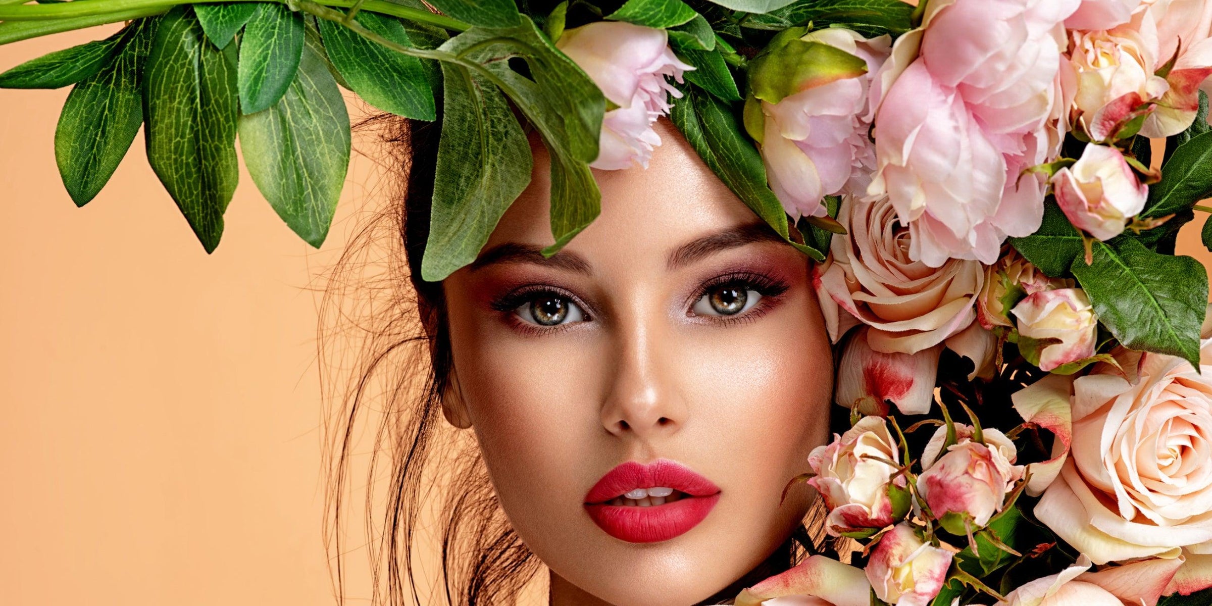 Frau mit rosafarbenen Rosen und grünen Blättern – exklusive Blumensträuße frisch geliefert