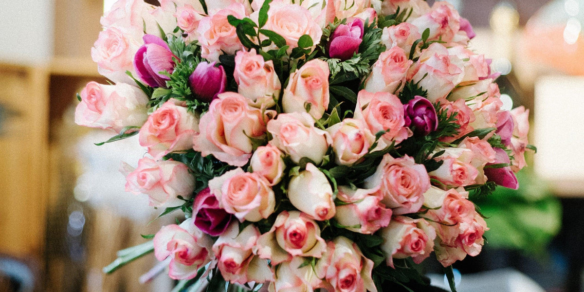Rosenstrauß mit rosa Rosen und lila Tulpen, frisch arrangiert für Geschenke und besondere Anlässe