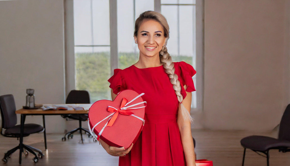 Frau in rotem Kleid hält Herz-Geschenkbox – perfekt für Blumensträuße & Geschenke mit Lieferung