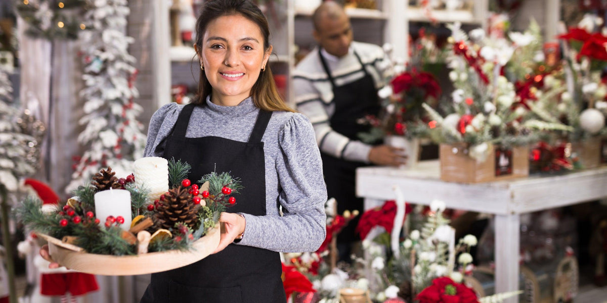 Weihnachtliche Tischdekoration mit Kerzen, Tannenzapfen und Beeren – frisch arrangiert für die Feiertage