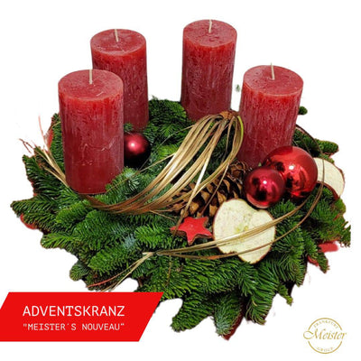 Adventskranz mit vier roten Kerzen, Tannenzweigen, roten Kugeln und getrockneten Äpfeln – festliche Weihnachtsdekoration