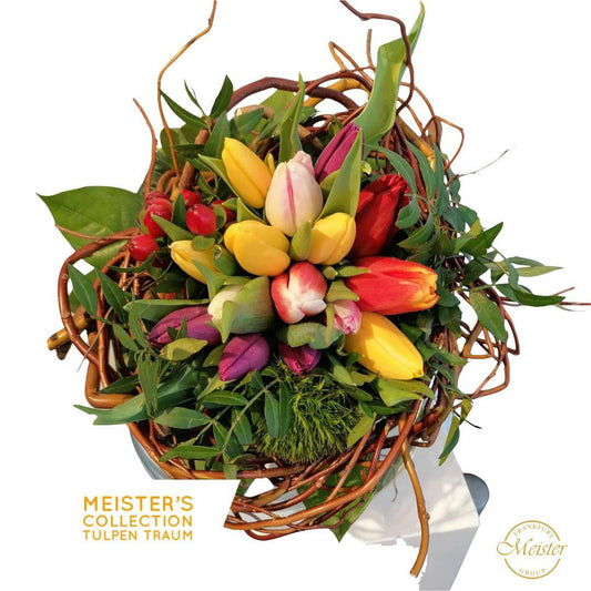 Bunter Tulpenstrauß in Weidenkorb mit grünen Blättern und roten Beeren – frisch und farbenfroh