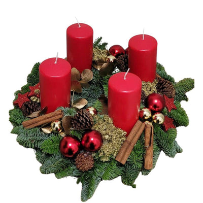 Adventskranz mit roten Kerzen, Tannenzweigen, Kiefernzapfen und Weihnachtskugeln